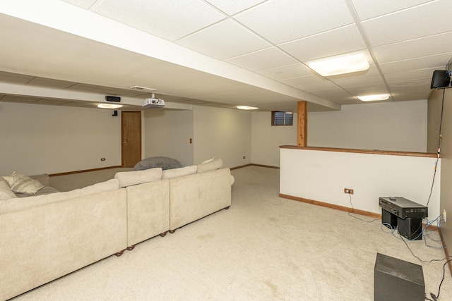 living room featuring carpet flooring, baseboards, and a drop ceiling