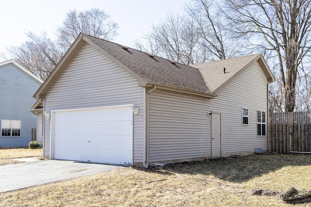 view of property exterior with an attached garage, driveway, roof with shingles, and fence