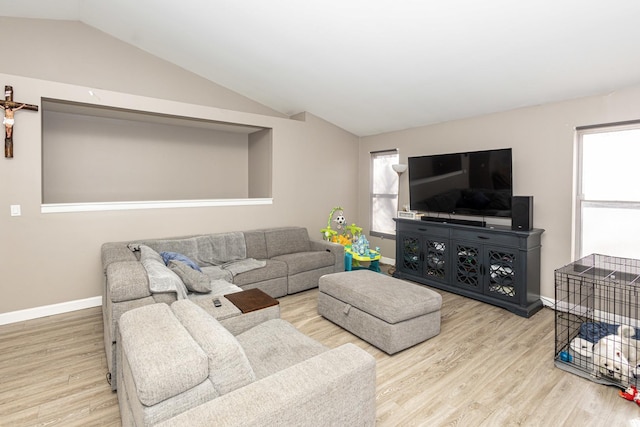 living area featuring baseboards, wood finished floors, and vaulted ceiling