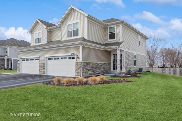 view of front facade with fence, driveway, a front lawn, a garage, and central air condition unit