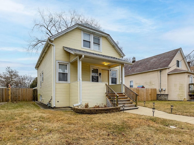 view of front facade with a front lawn and fence