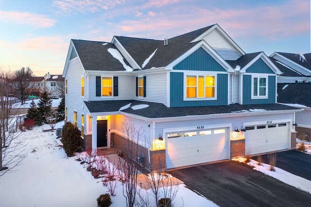 view of front of property with aphalt driveway, an attached garage, and brick siding