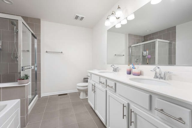 bathroom featuring visible vents, a stall shower, and a sink