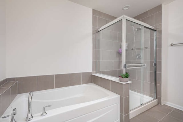 full bath featuring tile patterned floors, a shower stall, and a garden tub