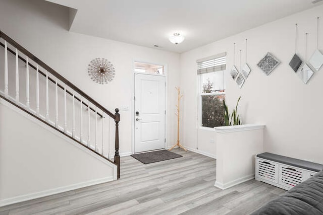 entrance foyer featuring stairway, baseboards, and light wood finished floors