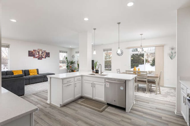 kitchen with light countertops, recessed lighting, stainless steel dishwasher, light wood-style floors, and a sink