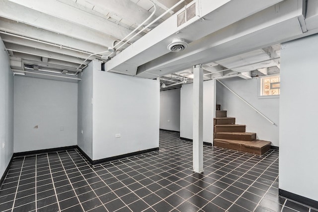 basement featuring visible vents, baseboards, and stairs