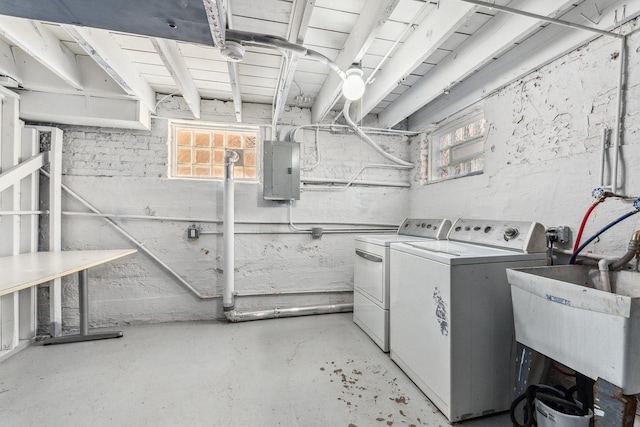 laundry area featuring laundry area, electric panel, washing machine and dryer, and a wealth of natural light