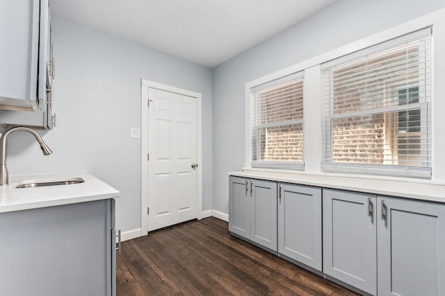 washroom featuring baseboards, dark wood-style flooring, and a sink