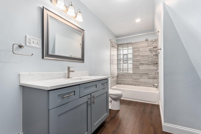 bathroom featuring baseboards, toilet, shower / bathing tub combination, wood finished floors, and vanity