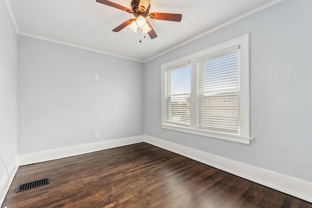 spare room with visible vents, baseboards, dark wood-style flooring, and crown molding