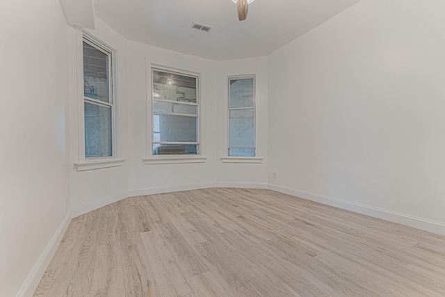 unfurnished room featuring visible vents, baseboards, wood finished floors, and a ceiling fan