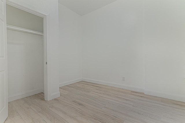 interior space with a closet, baseboards, and light wood finished floors