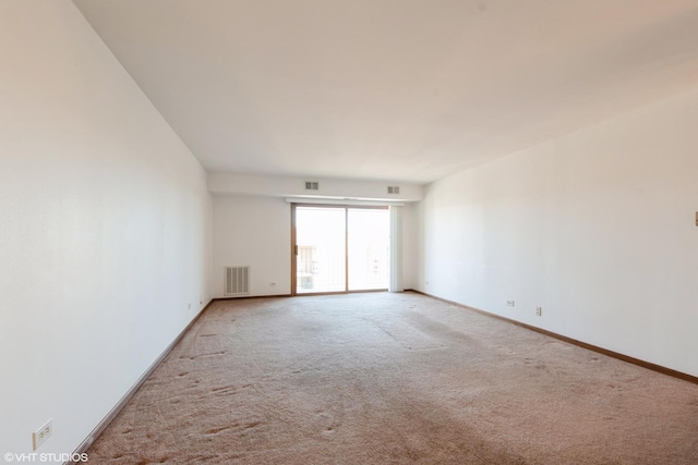 carpeted empty room featuring visible vents and baseboards