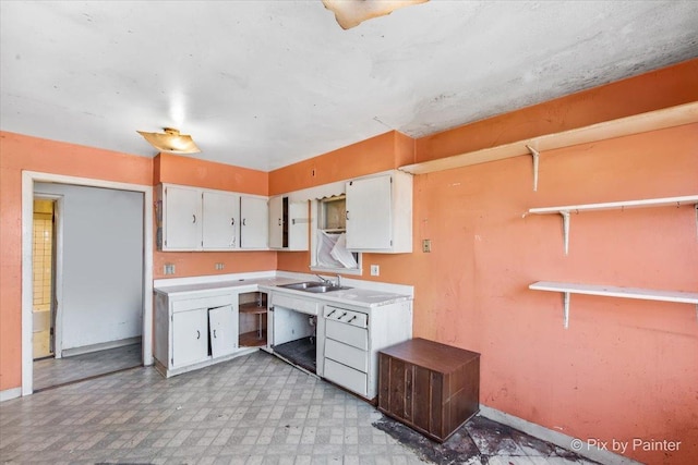 kitchen featuring light floors, dishwasher, light countertops, white cabinetry, and open shelves