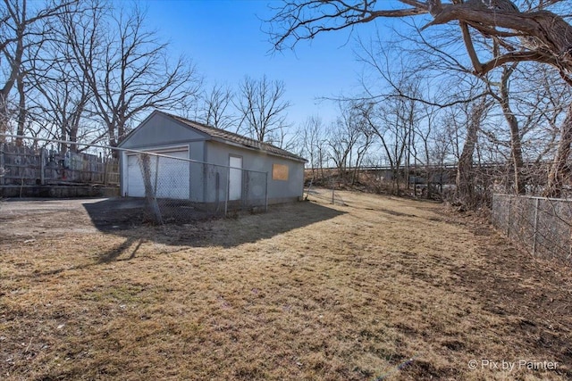 exterior space featuring a garage, an outdoor structure, and fence