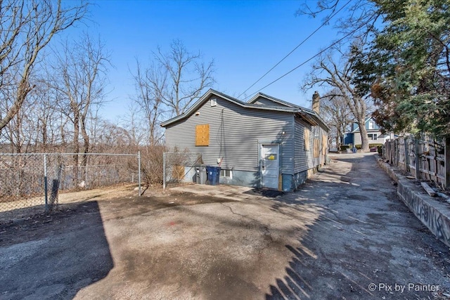 exterior space featuring a chimney and fence