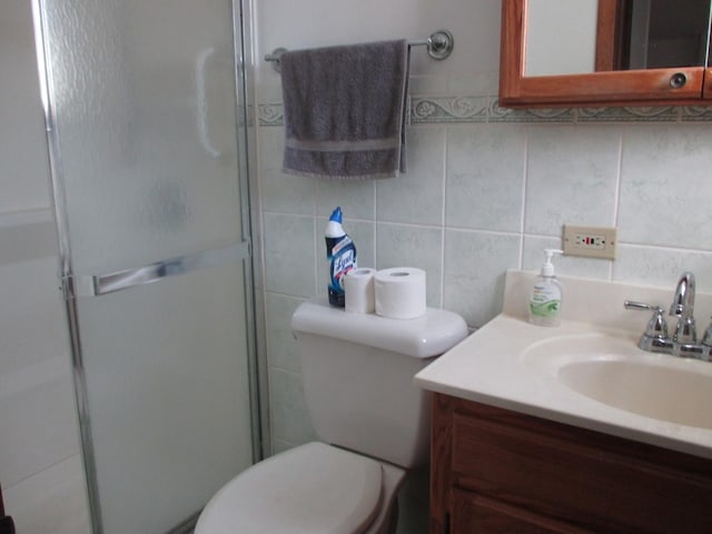 bathroom with toilet, tile walls, a shower stall, decorative backsplash, and vanity