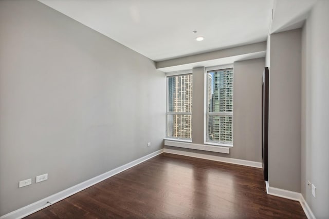 unfurnished room featuring baseboards and wood finished floors