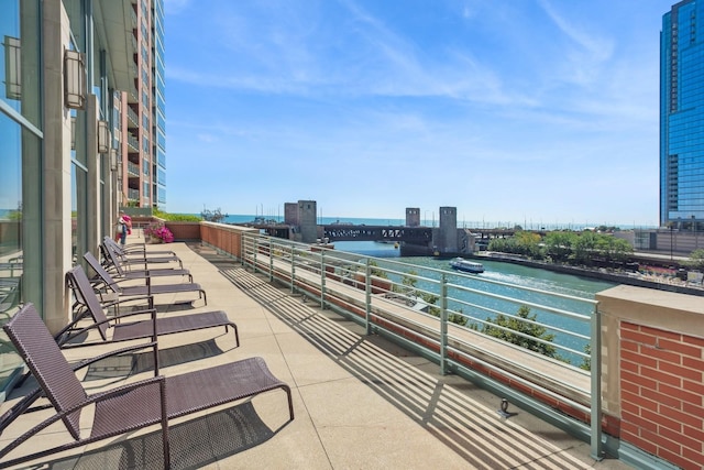 view of patio featuring a water view, a balcony, and a city view