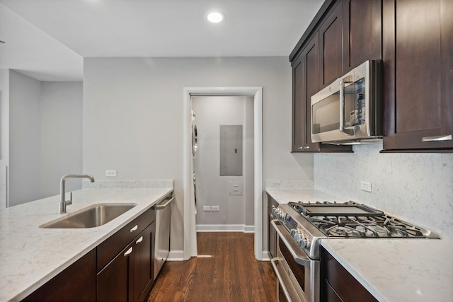 kitchen featuring a sink, dark wood-style floors, stainless steel appliances, light stone countertops, and dark brown cabinets