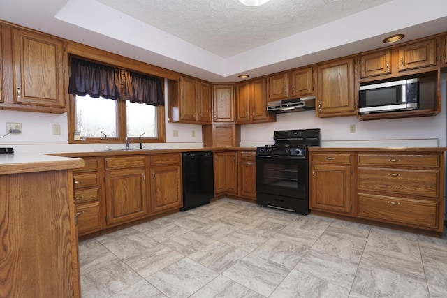 kitchen with black appliances, brown cabinetry, and under cabinet range hood