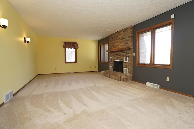 unfurnished living room featuring a wealth of natural light, visible vents, and a textured ceiling