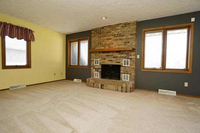 unfurnished living room with a fireplace, carpet, and visible vents