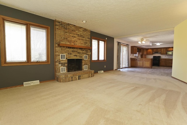 unfurnished living room featuring visible vents, light colored carpet, and a textured ceiling