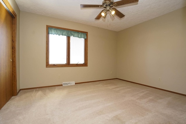 unfurnished bedroom with light carpet, visible vents, and a textured ceiling