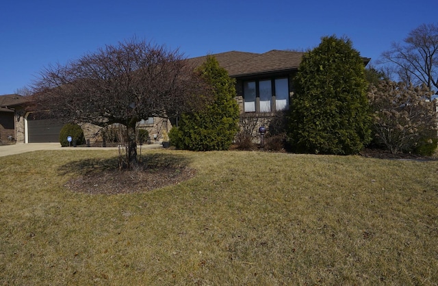 view of front facade with driveway, an attached garage, and a front lawn