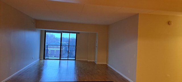 unfurnished room with wood finished floors and baseboards