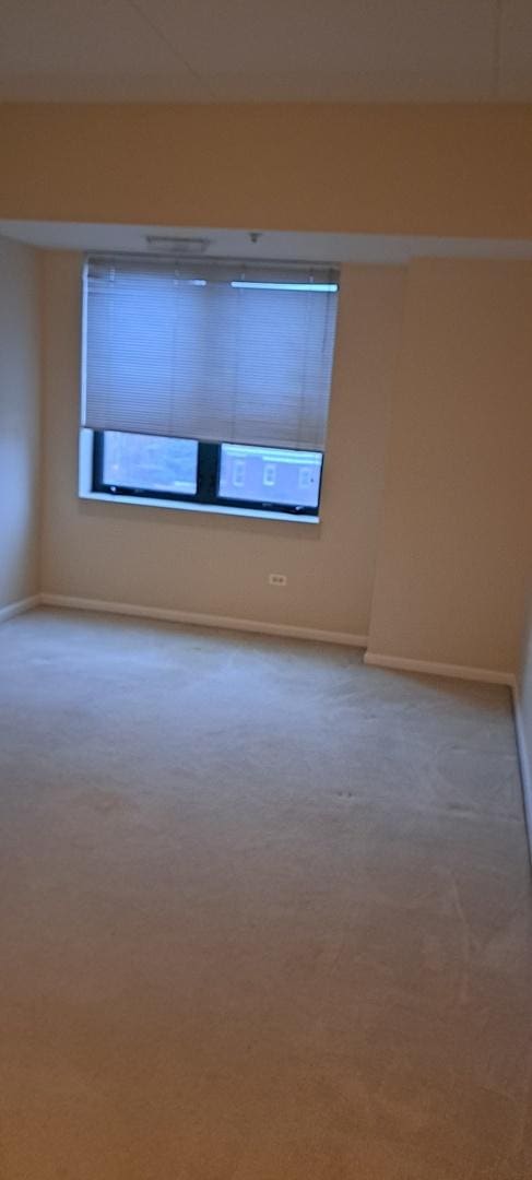 carpeted spare room with baseboards