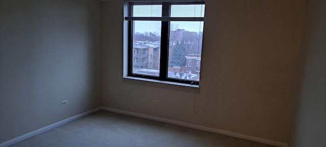 unfurnished room with light colored carpet and baseboards