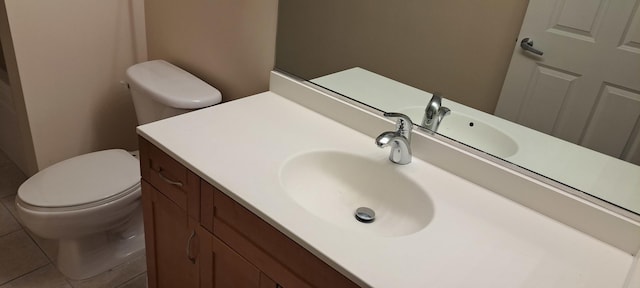 half bath featuring tile patterned floors, toilet, and vanity