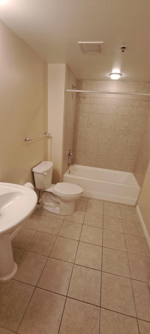 full bathroom featuring tile patterned floors, visible vents, toilet, and bathtub / shower combination