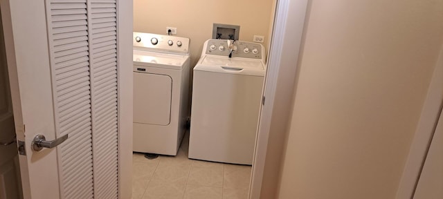 laundry area with washer and clothes dryer, laundry area, and light tile patterned floors