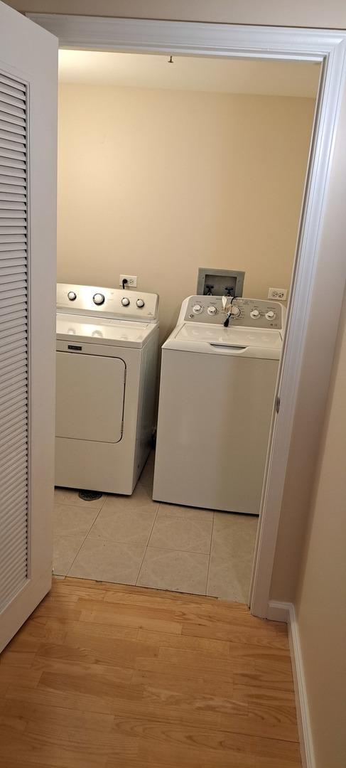 laundry area featuring laundry area, light wood-style flooring, and washing machine and dryer