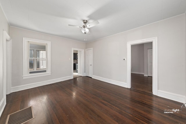 spare room featuring visible vents, baseboards, dark wood-type flooring, and ceiling fan