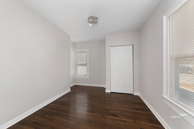 spare room featuring dark wood finished floors and baseboards