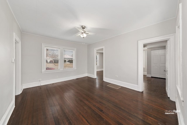 interior space featuring visible vents, baseboards, dark wood-type flooring, and ceiling fan