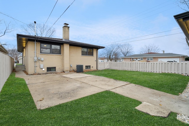 rear view of house featuring brick siding, central air condition unit, fence private yard, a lawn, and a chimney