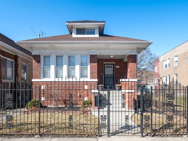 view of front facade with a fenced front yard, brick siding, and covered porch