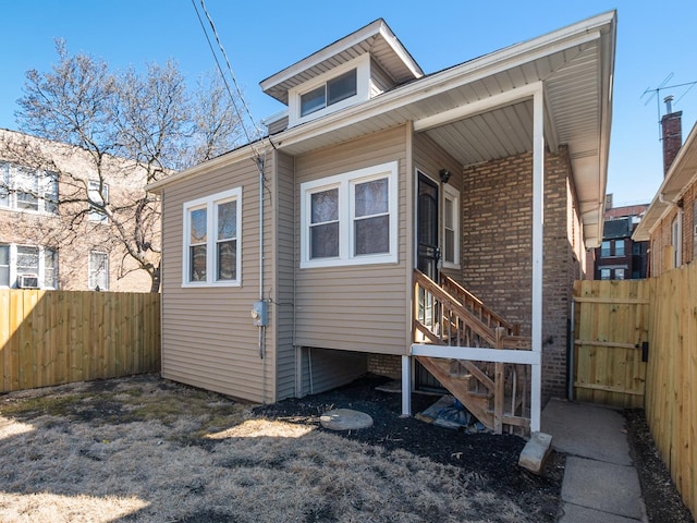 back of property with fence and brick siding