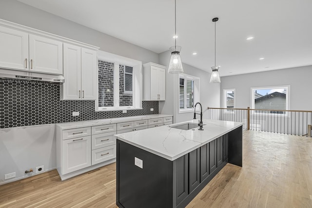 3308 S Leavitt St, Chicago, IL 60608 - kitchen featuring white cabinetry, a sink, light wood-type flooring, light stone counters, and backsplash