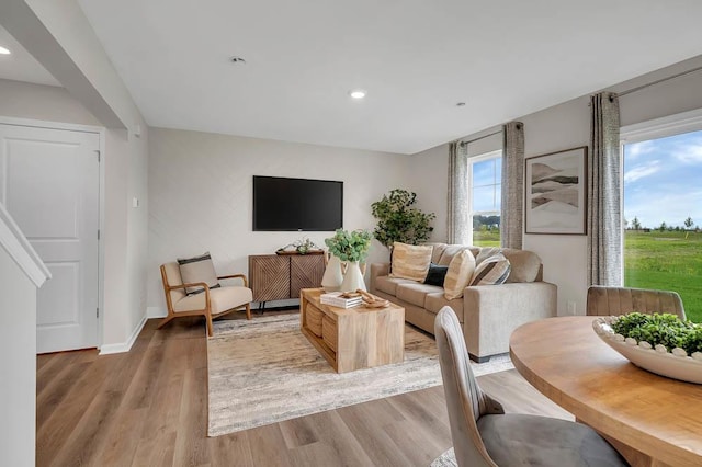 living area with recessed lighting, light wood-type flooring, and baseboards