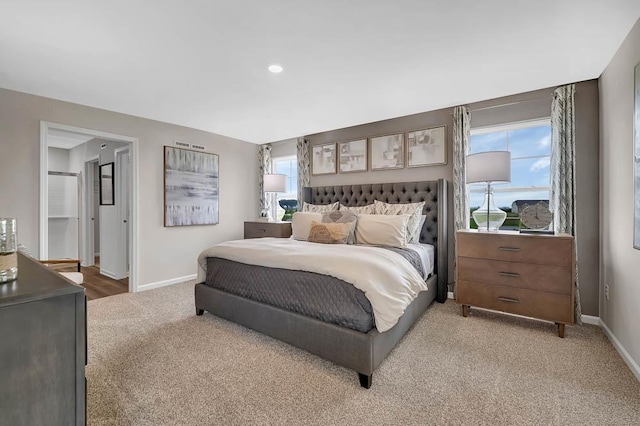 bedroom with light colored carpet and baseboards