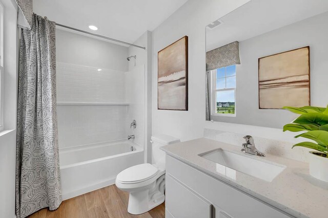 bathroom featuring shower / bath combo with shower curtain, toilet, wood finished floors, and vanity