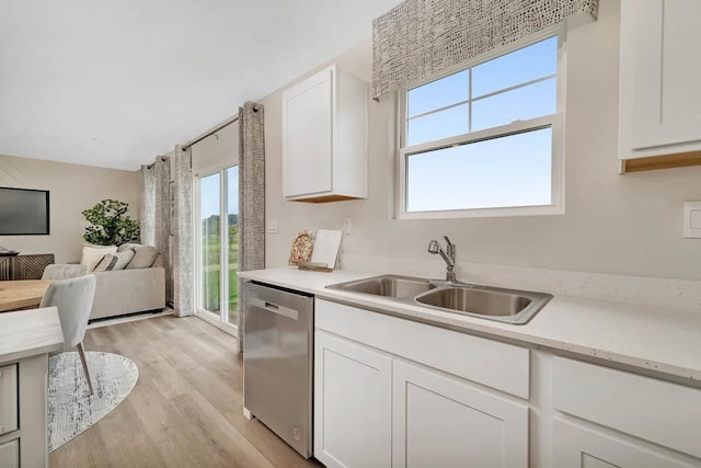 kitchen with a sink, dishwasher, white cabinets, and light countertops