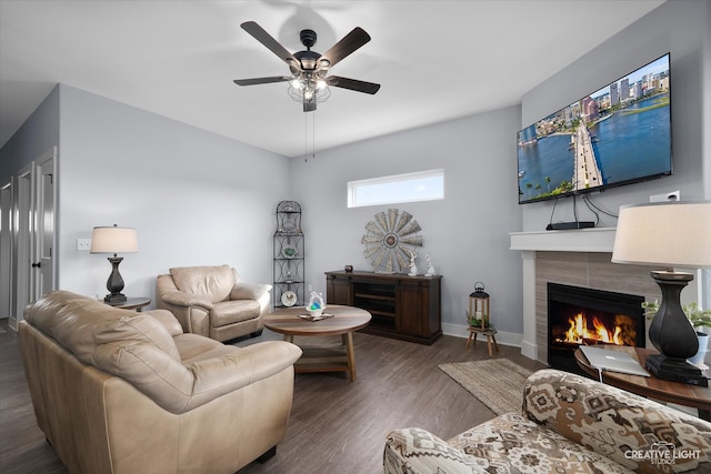 living area with ceiling fan, baseboards, wood finished floors, and a fireplace